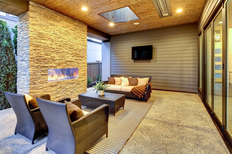 modern patio with fireplace, lounge chairs and outdoor entertainment system 