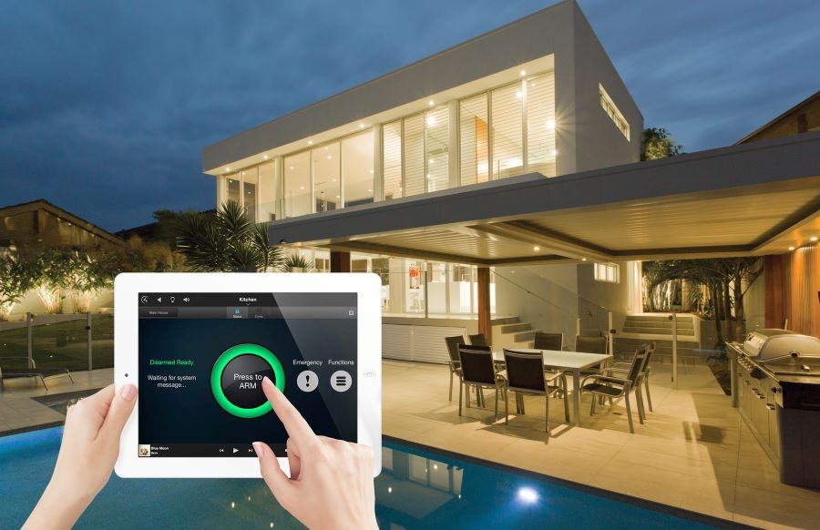 A backyard and pool area with an overlayed image of two hands holding a Control4 touchscreen and arming the alarm.